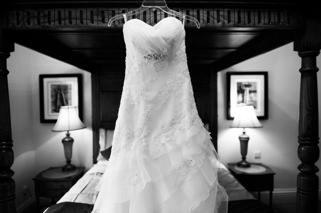 wedding dress on four poster bed black and white image
