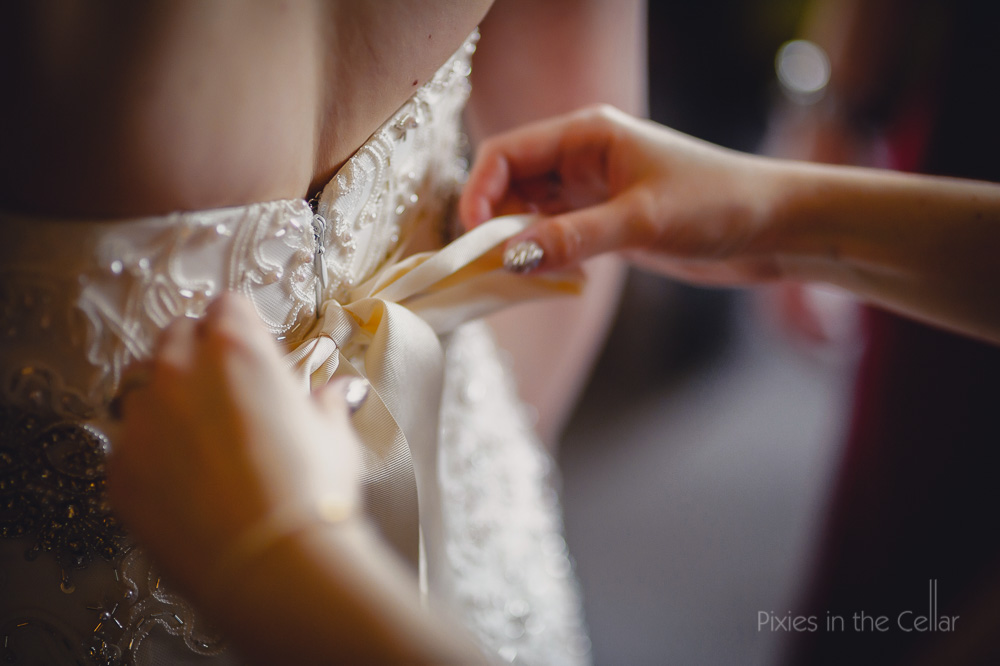 tying bow on wedding dress