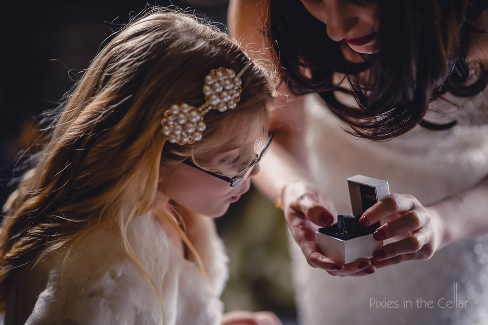 flower girl looking at wedding rings
