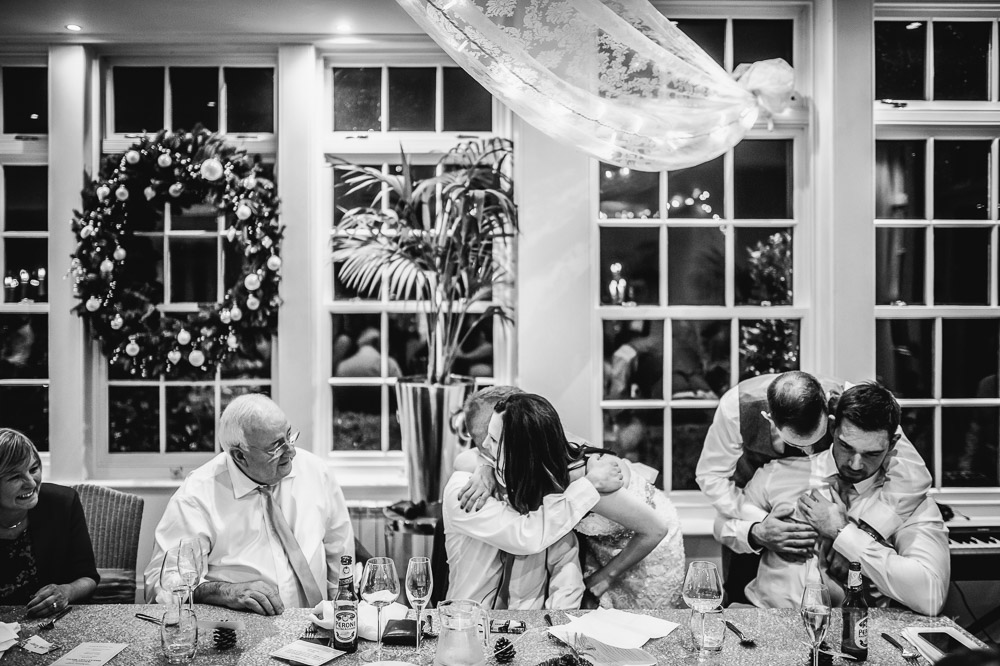 bride and groom hugging bestmen